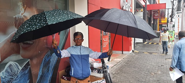Vendedores ambulantes comemoram aumento das vendas de sombrinhas e guarda-chuvas